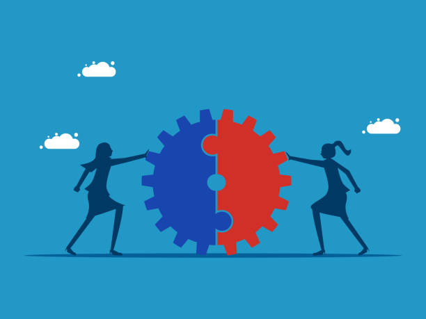 istock Business cooperation. Two businesswomen pushing a cogwheel together 1591570315