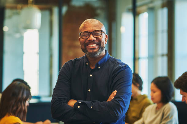 istock Cheerful bearded businessman smiling at camera in office 1591572396