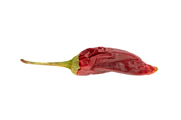 Deep red sun-dried chili pepper with stem isolated on white.