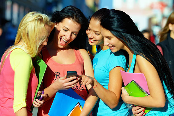group of students chatting in social network on mobile phone