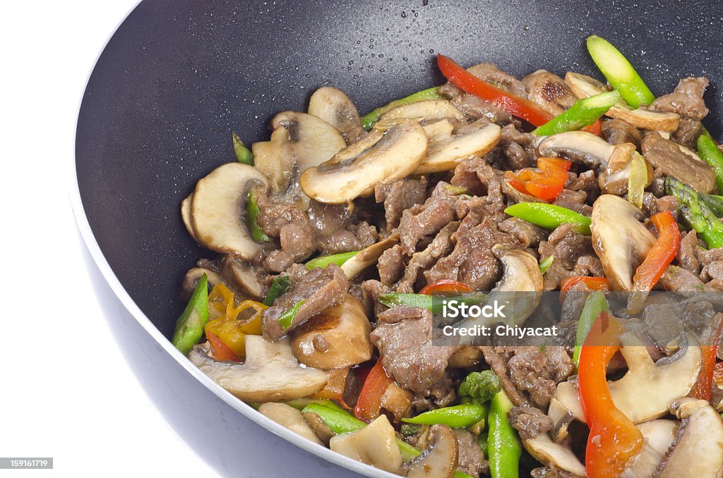 Stir-Fried Beef with Vegetables Stir-fried beef with mushrooms, asparagus and red bell pepper in a wok. Asian Food Stock Photo