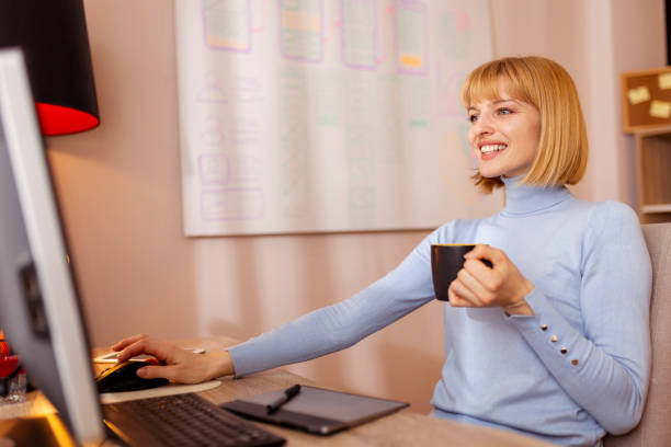 istock Woman drinking coffee while working in home office 1591629123