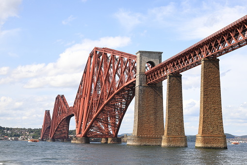 South Queensferry, Scotland - June 21:  The view from South Queensferry in the east of Scotland towards the Forth Bridge on June 21, 2023.  The cantilever railway bridge crosses the Firth of Forth.