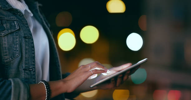 istock Hands, night or woman typing on tablet in office working on email or digital research project online. Social media, closeup or female professional writing agenda report, planning or internet late 1591642676