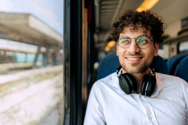 istock Young smiling handsome man enjoying train ride 1591657876