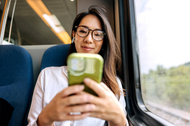 istock Young smiling businesswoman using mobile phone while riding i a train 1591658278