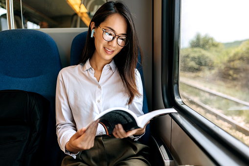 Woman reading book while traveling with the train