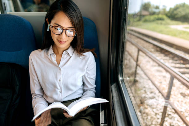 istock Woman reading book while traveling with the train 1591658353