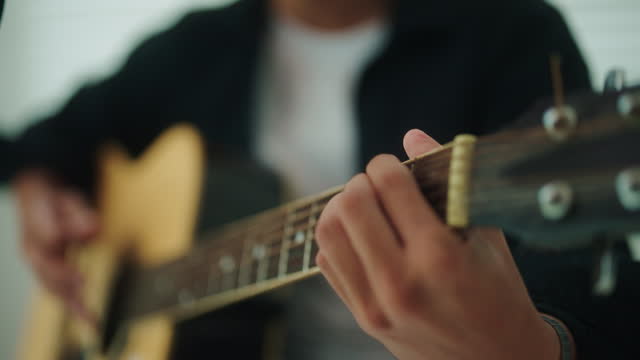 Close-up hand playing guitar.