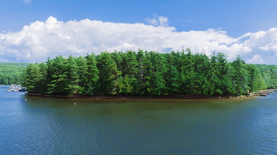An aerial view of Deep Creek Lake in Maryland, USA, with a small island in the center with pine trees