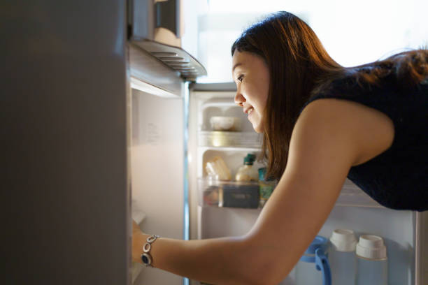 istock Woman finding a foods in refrigerator. 1591662047