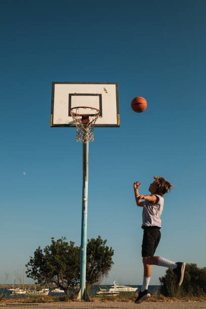 istock Child throwing ball into hoop on court 1591662798