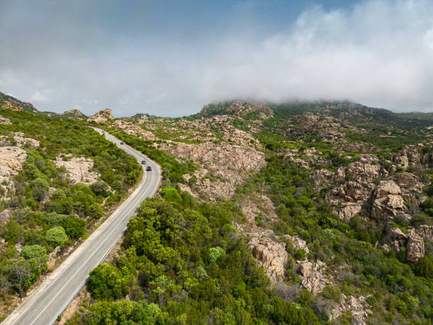 Landscape in Gallura, with granite rocks and mountain in background, fog or low clouds