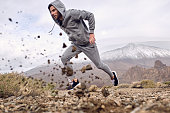Hispanic man running fast in mountains