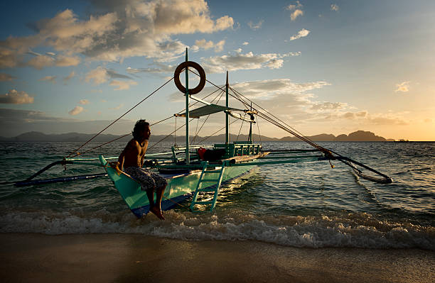 philippino com sua tradicional banca outrigger barcos nas filipinas - outrigger philippines mindanao palawan - fotografias e filmes do acervo