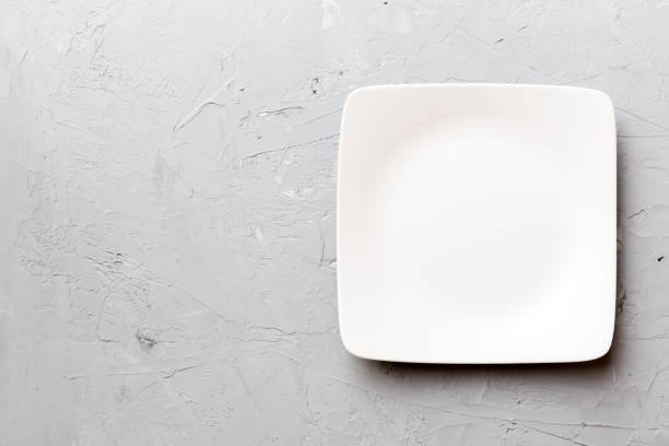 istock Top view of empty square plate on cement background. Empty space for your design 1591716253