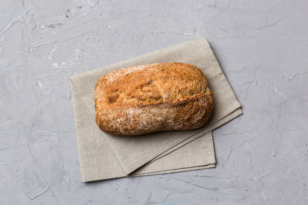 istock Fresh Homemade Whole Wheat Bread. bread on napkin on rustic background, fresh bread top view 1591716281