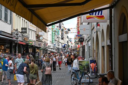 People shopping in the streets of Zwolle during the annual Blauwvingerdagen market fair held every year on wednesdays in July. People are looking at the market stalls and enjoying food and drinks at the outdoor bar seatings.
