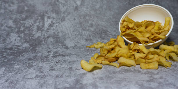istock Cassava chips in white plastic bowl isolated on gray background 1591725609