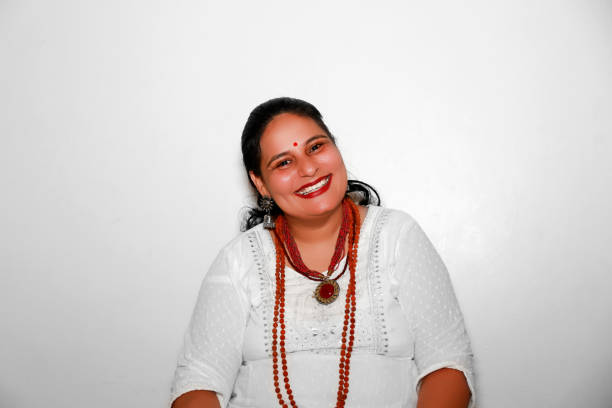 Cheerful female monk or sadhu of Indian ethnicity wearing rudraksha sitting portrait isolated on white background.