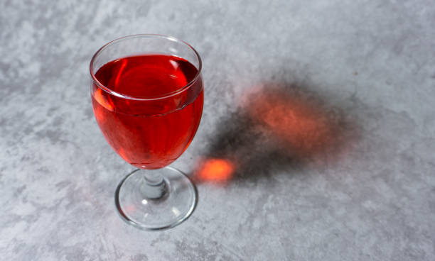 sirop rouge aromatisé à la framboise dans une tasse en verre isolée sur fond gris - editorial label man made material healthcare and medicine photos et images de collection