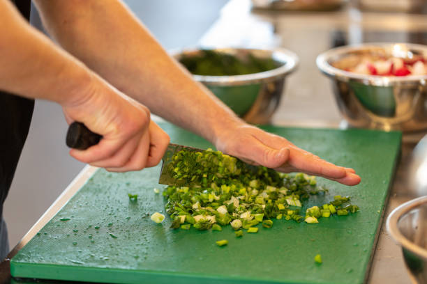Cook's hands chop finely green onions