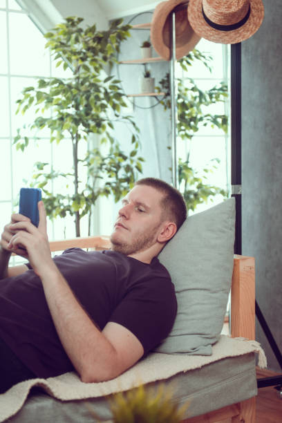 istock Male Exploring Social Media On Smartphone While Lying Down At Home 1591776158
