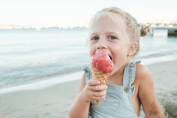 istock Happy girl enjoying ice cream on beach 1591782244