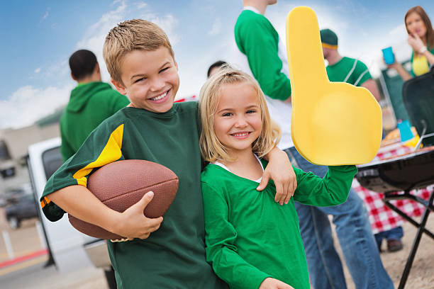 Kids cheering sports team during college football stadium tailgate party Kids cheering sports team during college football stadium tailgate party.  people family tailgate party outdoors stock pictures, royalty-free photos & images