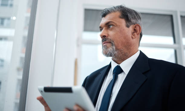 istock Business, ideas and senior man with a tablet, thinking and connection with network, project and digital planning. Consultant, inspiration and entrepreneur with technology and strategy in a workplace 1591794336
