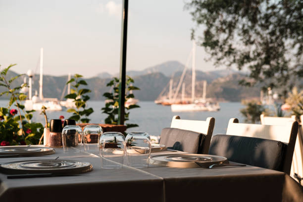 istock served table in coast seaside restaurant, white and blue colors, sunset time, dinner at seaview with sailing boats at anchor 1591802593