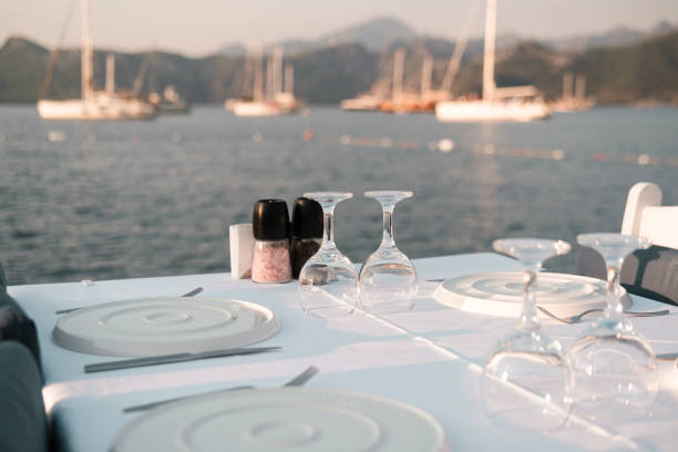 istock served table in coast seaside restaurant, white and blue colors, sunset time, dinner at seaview with sailing boats at anchor 1591802611