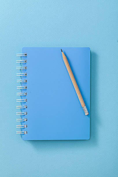 istock Blue Notepad With Wooden Pencil Close Up. 1591811438