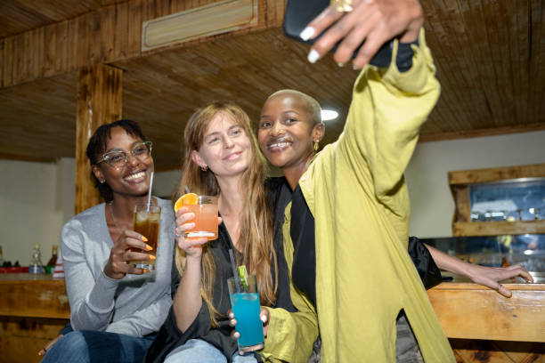 istock Young female friends taking selfie while socializing 1591813196