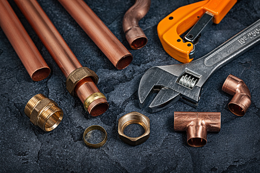 Copper Pipes And Fitting Connectors For Plumbing On Black Background