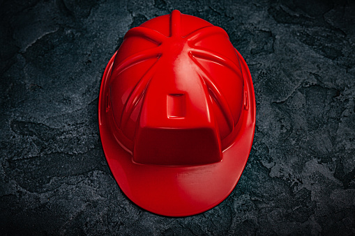 Red Construction Helmet On Dark Stone Background