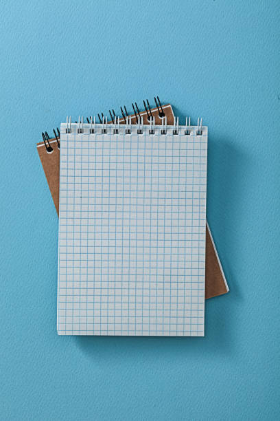 dos blocs de notas abiertos sobre fondo azul. - spiral notebook open note pad textbook fotografías e imágenes de stock