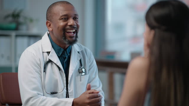 Happy, doctor and conversation with woman in office to help, support or talk to patient or medical advice and customer care. Black man, speaking and person with trust in healthcare and consultation