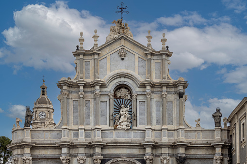 Catania, Sicily, Italy - April 30, 2023: Facade of baroque Catania Cathedral (Metropolitan Cathedral of Saint Agatha) with statue of Saint Agatha