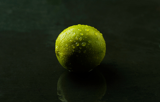 Limes on dark marble, dark studio shot
