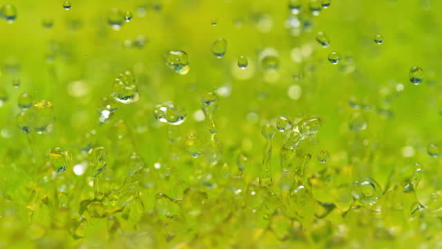 Yellow Green Soda Splashing in Slow Motion - Abstract Glowing Bouncing Liquid Makes Droplets and Splashes