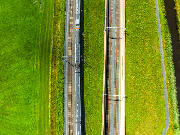 istock Railroad tracks with a train passing seen from above 1591888851