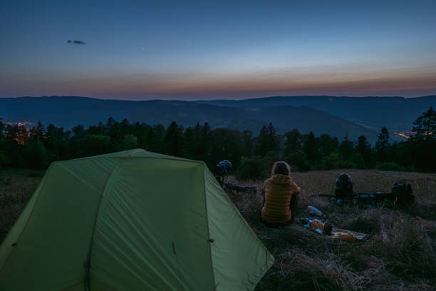 istock Woman camping at night contemplates the sky 1591907775