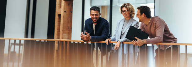 istock Creative design team stands on an interior balcony discussing business ideas 1591927393