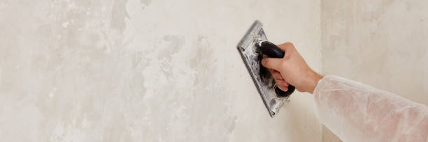istock Hand of a man sanding a wall after plastering 1591928499
