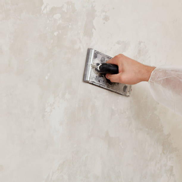istock Hand of a man sanding a wall after plastering 1591928516