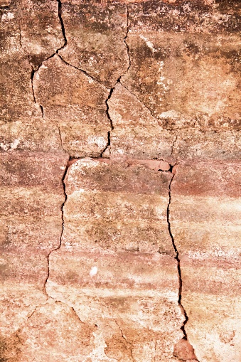 a photography of a cracky wall with a small white dot, a close up of a crack in a wall with a red fire hydrant.