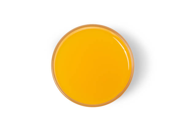istock The orange water glass is captured from a high angle against a white background. 1591965905