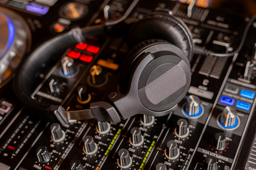 Headphones on dj console deck Big dj headphones to mix music at night club party Professional headset