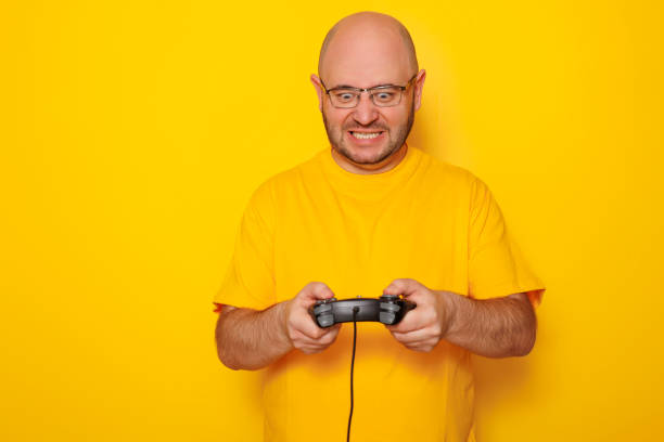 istock Man playing video games on yellow background 1591992461